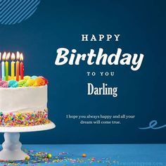 a birthday cake with lit candles and sprinkles is on a blue background