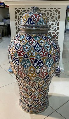 a large vase sitting on top of a tiled floor