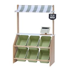 a wooden shelf with six green dishes and a sign that says we are off - ex