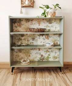 a green bookcase with wallpaper on it