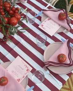 the table is set with tomatoes and place settings