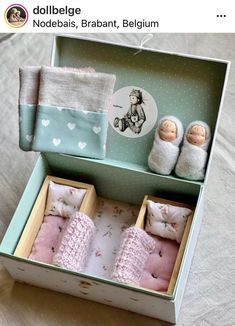 an open box with two baby dolls in it