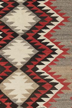 an old navajo rug with red, brown and white colors