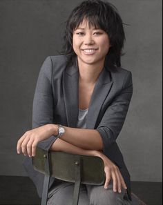 a woman sitting on top of a chair with her arms crossed