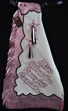 a pink and white bag with fringes on it's side, decorated with the words new orleans christmas tree