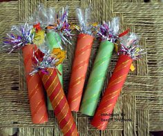 four different colored candles sitting on top of a wicker mat with tinsel wrapped around them