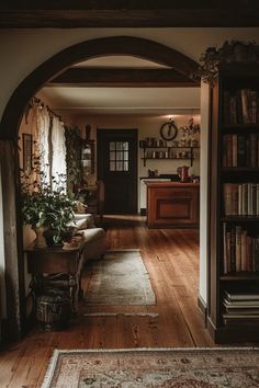 an archway leads into a living room with bookshelves and a rug on the floor