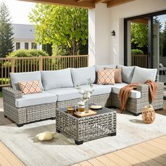 an outdoor living room with wicker furniture and wood flooring on the outside deck