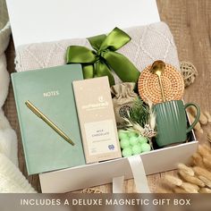 an open box containing various items such as books, notebooks and coffee mug sitting on top of a wooden table