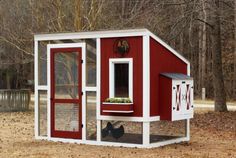 a red and white chicken coop in the woods