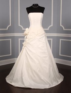 a white wedding dress on display in a room