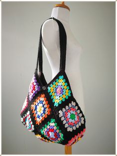 a crocheted bag is displayed on a mannequin