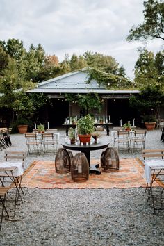 tables and chairs are set up for an outdoor wedding reception in the garden with potted plants on top