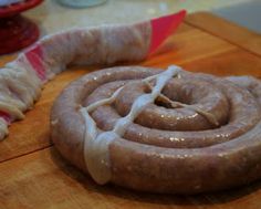 two sausages sitting on top of a wooden cutting board