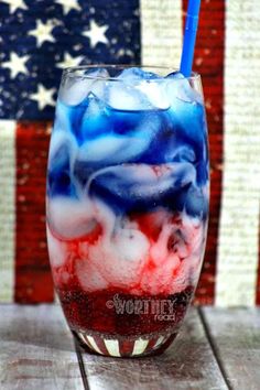 an american flag drink in a glass with a straw sticking out of the top, on a wooden table