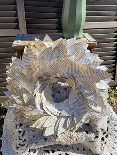 a white crocheted doily sitting on top of a wooden chair next to a green plant