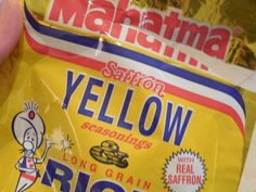 a bag of yellow rice sitting on top of a counter next to a person's hand