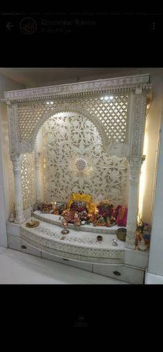 an ornate white bed with flowers and candles on it's headboard in a room