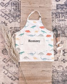 an apron with the word remmy printed on it next to a whisk