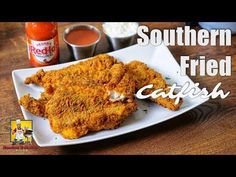 fried chicken on a white plate with sauces and ketchup in the background