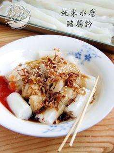 a white plate topped with dumplings and chopsticks