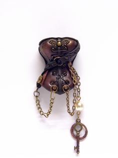 an old fashioned steampunky purse with chain and key attached to the back