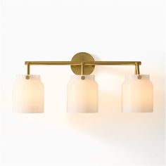 three light brass bathroom fixture with frosted glass shades on the front and back sides