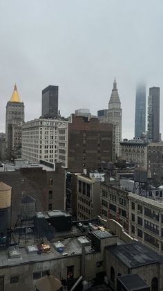 the city skyline is covered in fog and smoggy skies, as seen from an apartment building