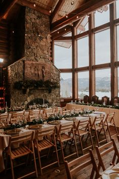 tables and chairs are set up in front of a stone fireplace