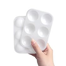 a hand holding two ice cubes on top of each other in front of a white background