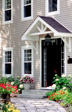 a house with flowers in the front yard and walkway leading to the front door area