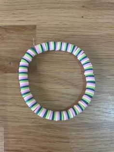 a close up of a wooden table with a bracelet made out of strips of paper