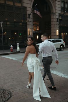 a man and woman are walking down the street