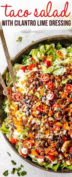 taco salad with cilantro lime dressing in a large serving dish on a white table