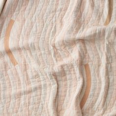 an unmade bed with a pink and white bedspread