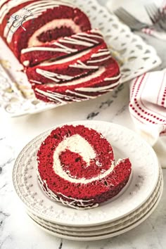 red velvet cake with white frosting and swirly icing on plates next to it