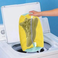 someone is holding a sponge over the top of a washing machine