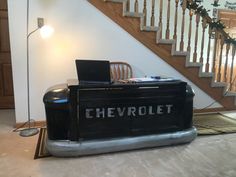 a laptop computer sitting on top of a desk in front of a stair case with the word chevrolet written on it