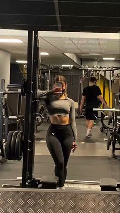 a woman standing in front of a gym machine