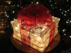 a lighted present box sitting on top of a wooden table