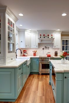 a kitchen with blue cabinets and white counter tops, hardwood floors, and stainless steel appliances