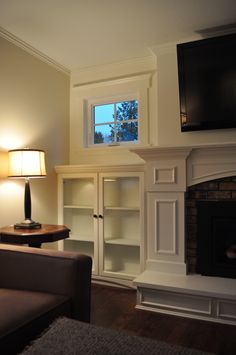 a living room with a couch, television and fireplace