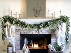 a fireplace decorated for christmas with stockings and garland