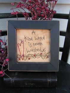 a black frame sitting on top of a wooden table next to a potted plant