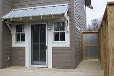 a small gray house with a white door and window