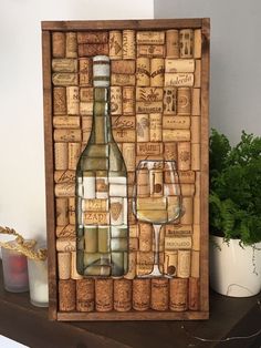 a wine bottle and glass sitting on top of a wooden shelf next to a potted plant