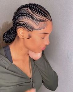 a woman with braids in her hair is looking down at the ground and has one hand on her shoulder