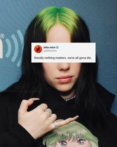 a woman with green hair and piercings holding her finger up to the camera while wearing a black shirt