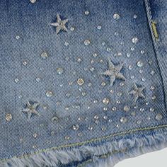 a pair of denim shorts with stars and sequins on the side, close up