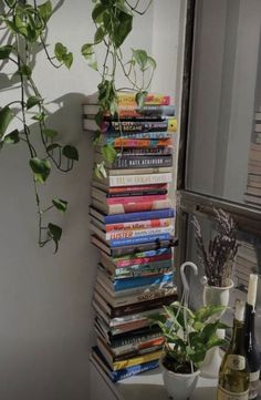 a stack of books sitting on top of a table next to a bottle of wine